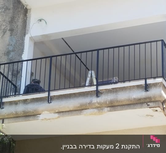 מעקה מתכת שחור על מרפסת בטון